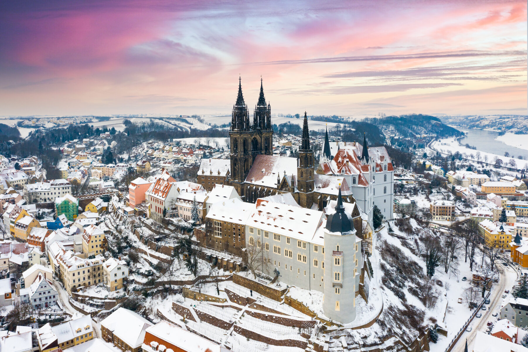Eine Stadt überdeckt mit Schnee und einem bunten Himmel