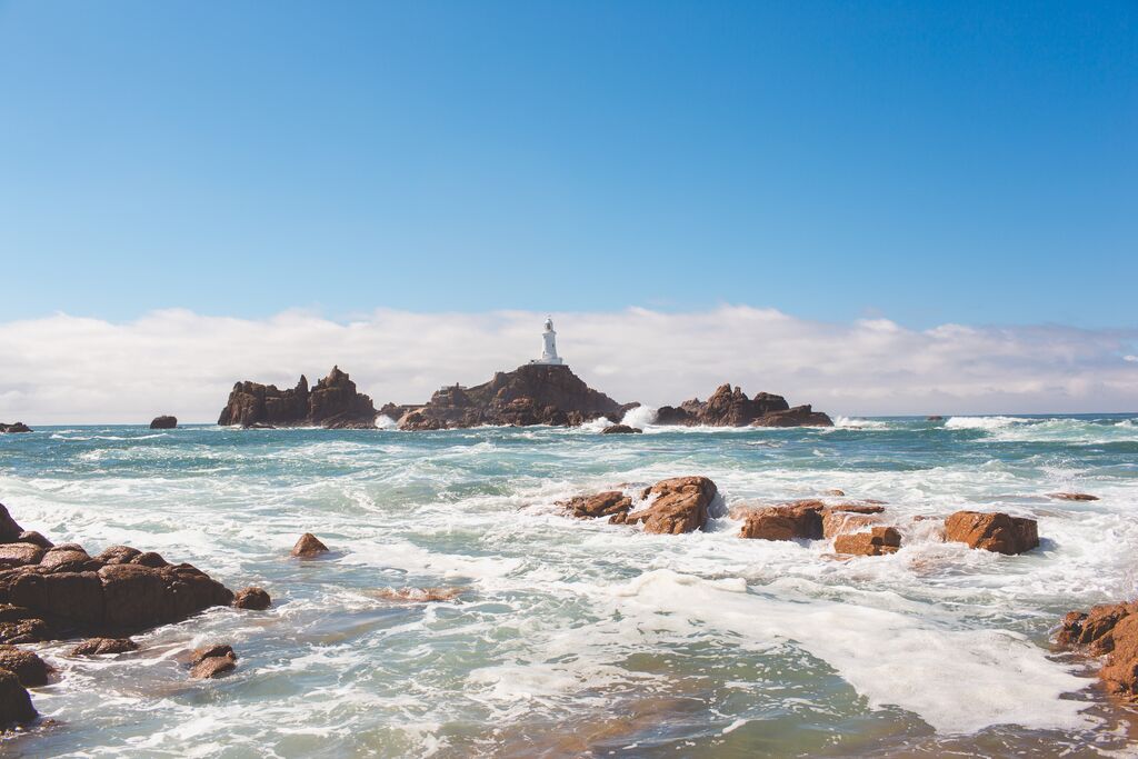 Meer mit Felsen und einem Leuchtturm