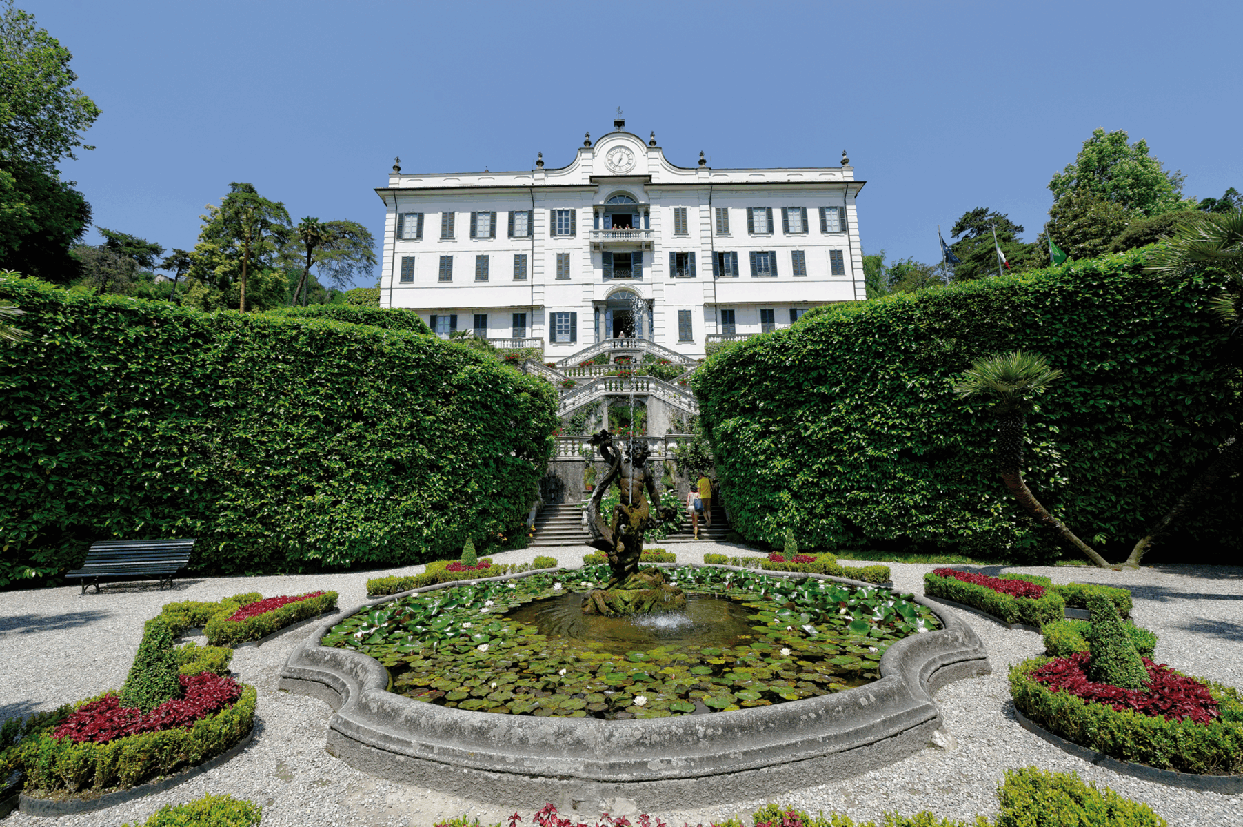Ein Springbrunnen vor einer weißen Villa