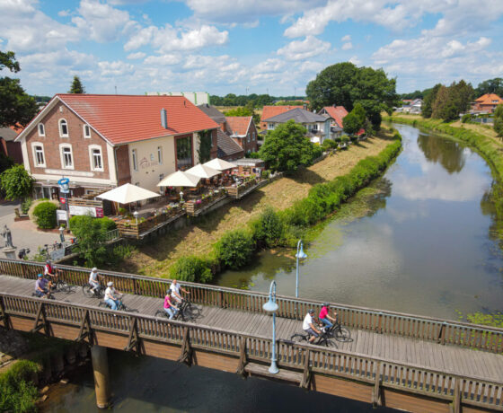 Über eine Brücke fahren Menschen mit ihren Fahrrädern