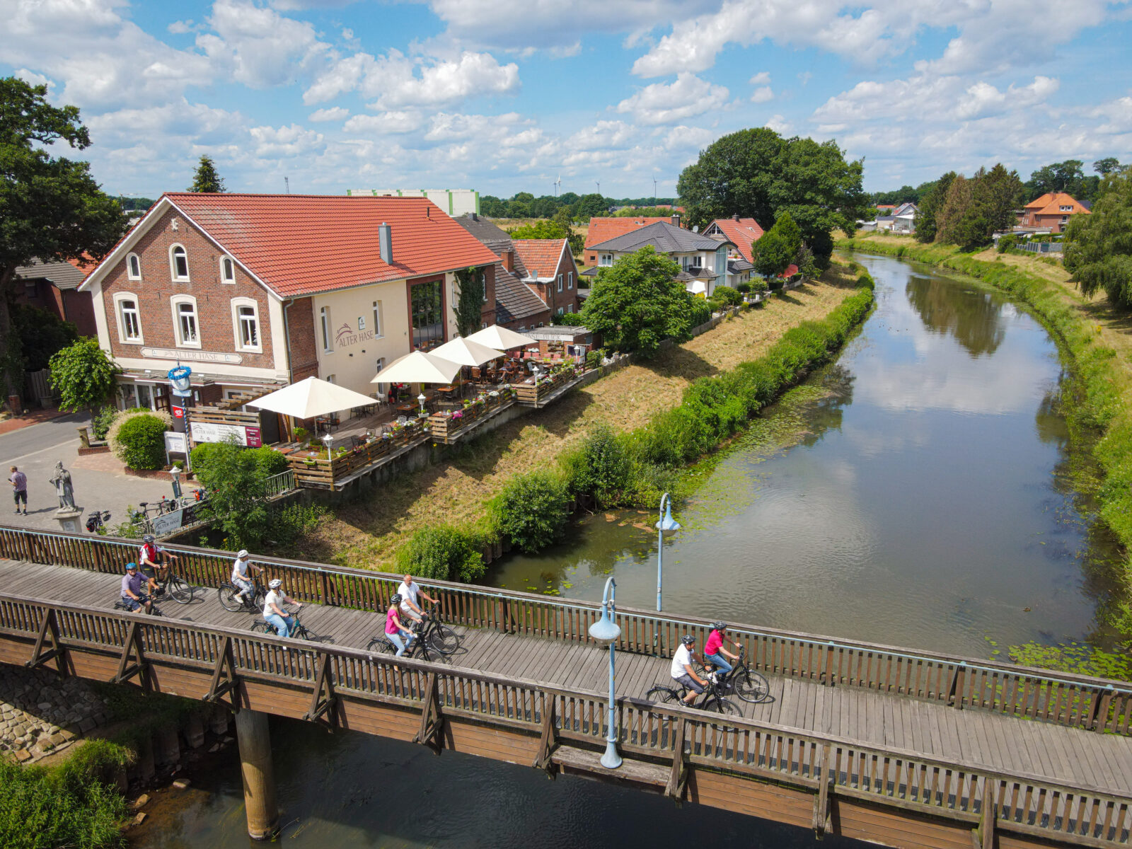 Über eine Brücke fahren Menschen mit ihren Fahrrädern